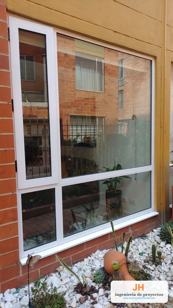 Ventana termoacústica Zinú de sala en aluminio blanco con paño fijo grande y naves batientes, doble vidrio hermético, casa en Bogotá, obra de JH
