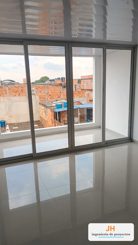 Puerta ventana corrediza Kimbaya (Eurovitral) en aluminio gris de tres hojas, salida a balcón de apartamento en Bogotá, obra de JH