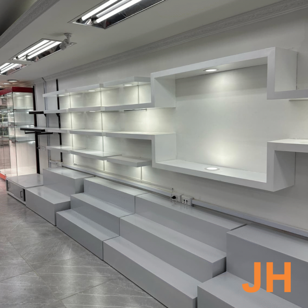 Montaje comercial con estanterías flotantes blancas y luz LED integrada, diseñado para exhibiciones modernas y elegantes.