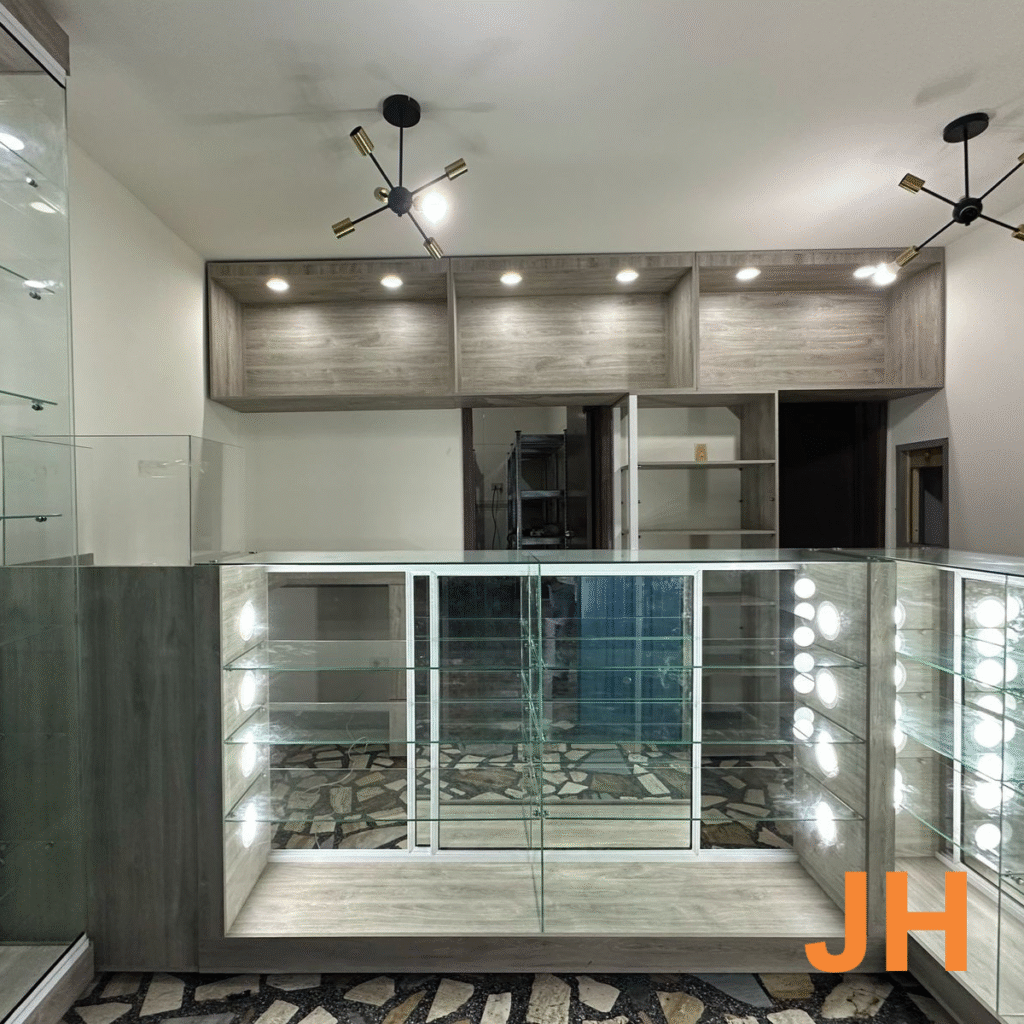Montaje comercial con vitrinas de vidrio y luces LED integradas para realce de productos.