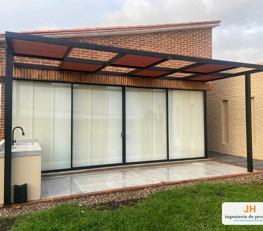 Pérgola en acero cold rolled pintado negro con cubierta en policarbonato bronce sobre terraza BBQ con puerta ventana corrediza, obra de JH en la sabana de Bogotá