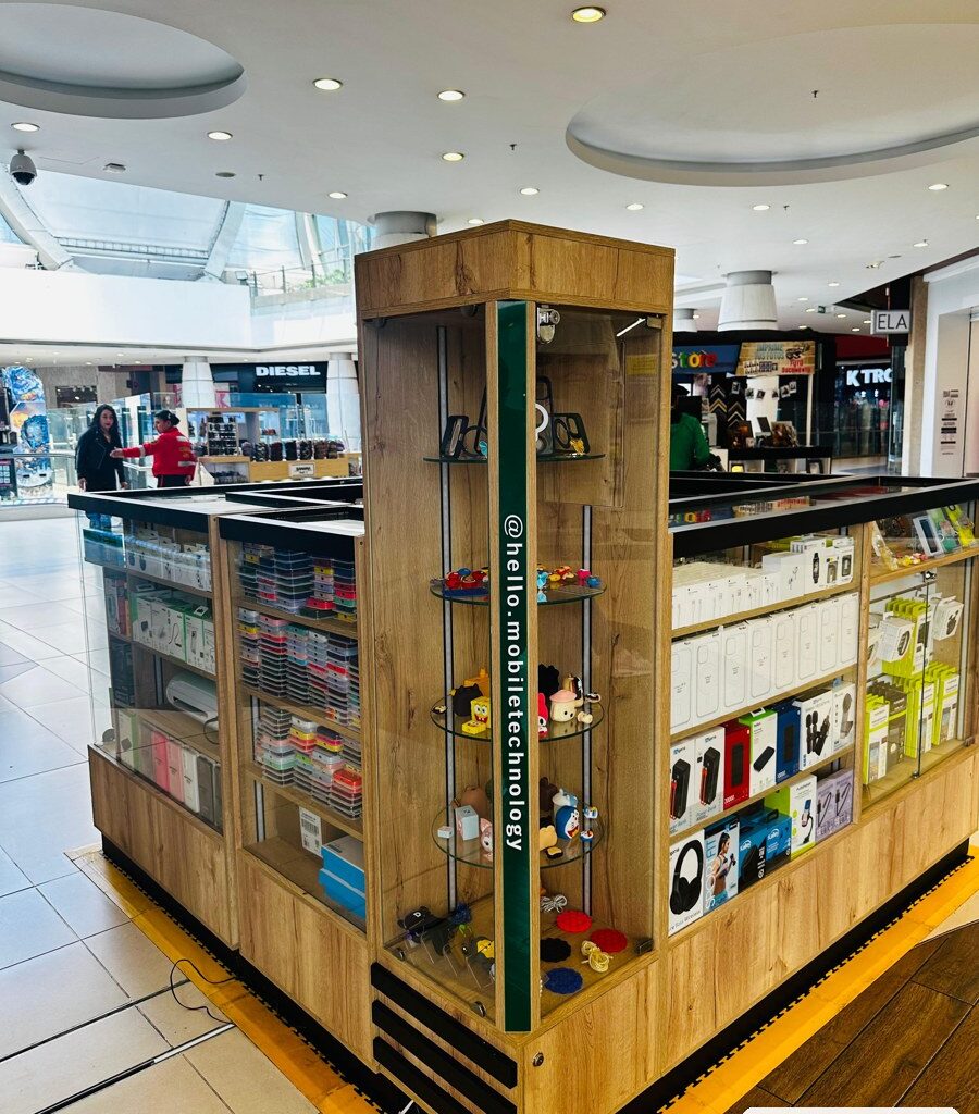 Isla comercial para celulares y accesorios en centro comercial de Bogotá, vitrinas mostrador en vidrio templado con LED, torre de esquina y base en madera, obra de JH