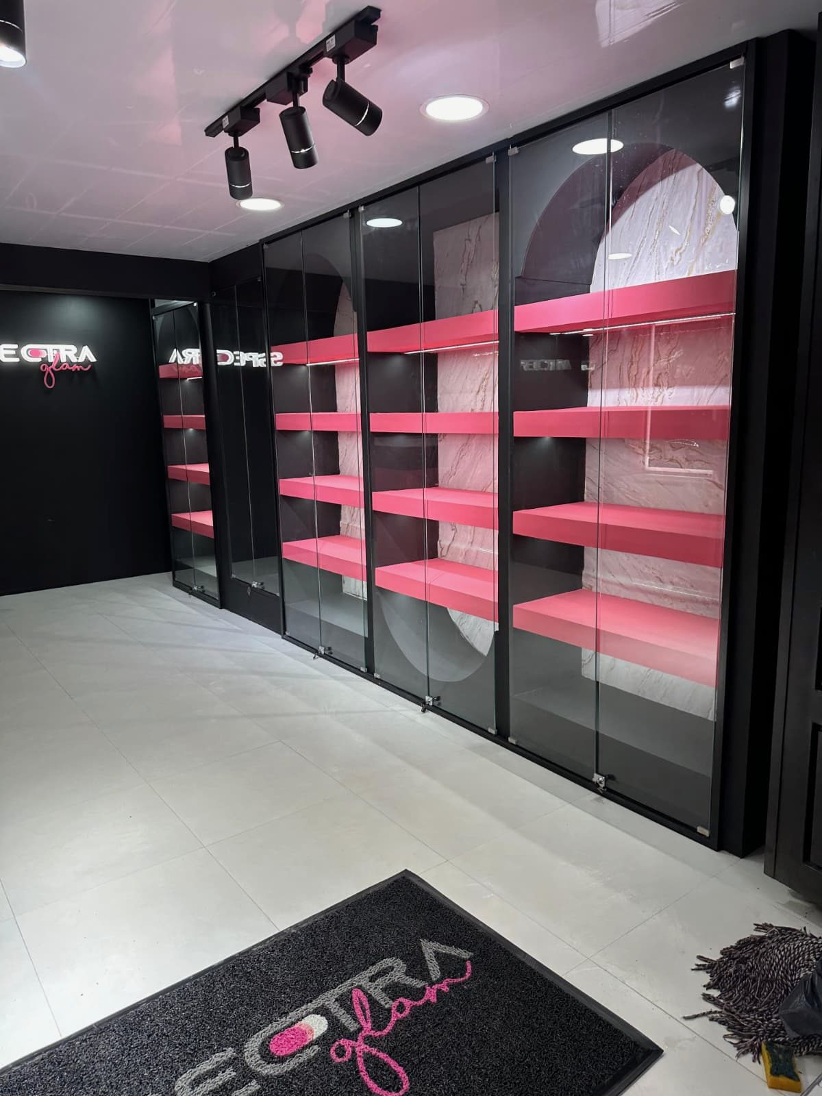 Montaje de local de belleza con vitrinas negras y estantería rosa — Spectra, Bogotá